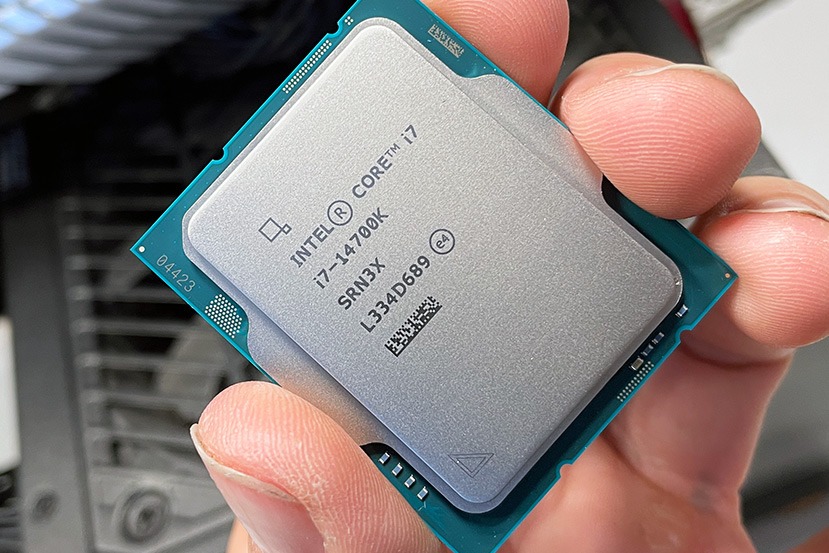 Intel Core i7-14700K processor held in hand showing the heat spreader markings