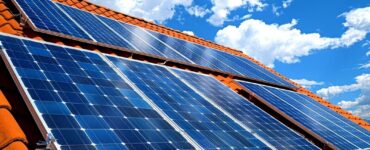 Solar panels installed on a rooftop under bright blue sky in Multan